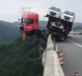 carcarrier-truck-cab-hanging-off-bridge-railing.webp