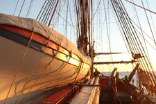 1200px-Pinnace_onboard_the_replica_HMB_Endeavour_at_sunrise.webp