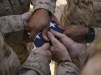 stk102498m~Marines-Fold-an-American-Flag-after-It-was-Raised-in-Memory-of-a-Fallen-Soldier-Pos...jpg