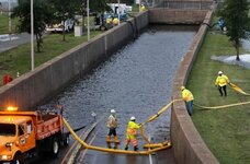 Virginia DOT workers place hose to pump out flood water at thewentrance of Midtown Tunnel prio...jpg