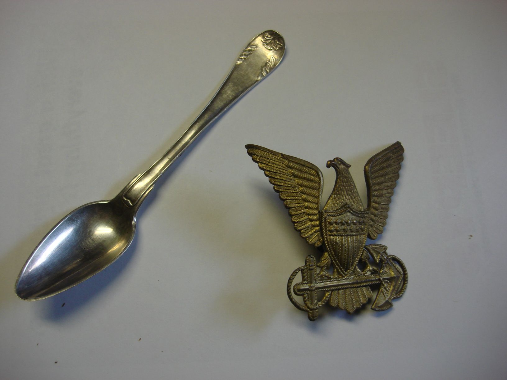 An 1825 83% silver Swedish spoon and a 1930's United States Coast Guard Hat Badge