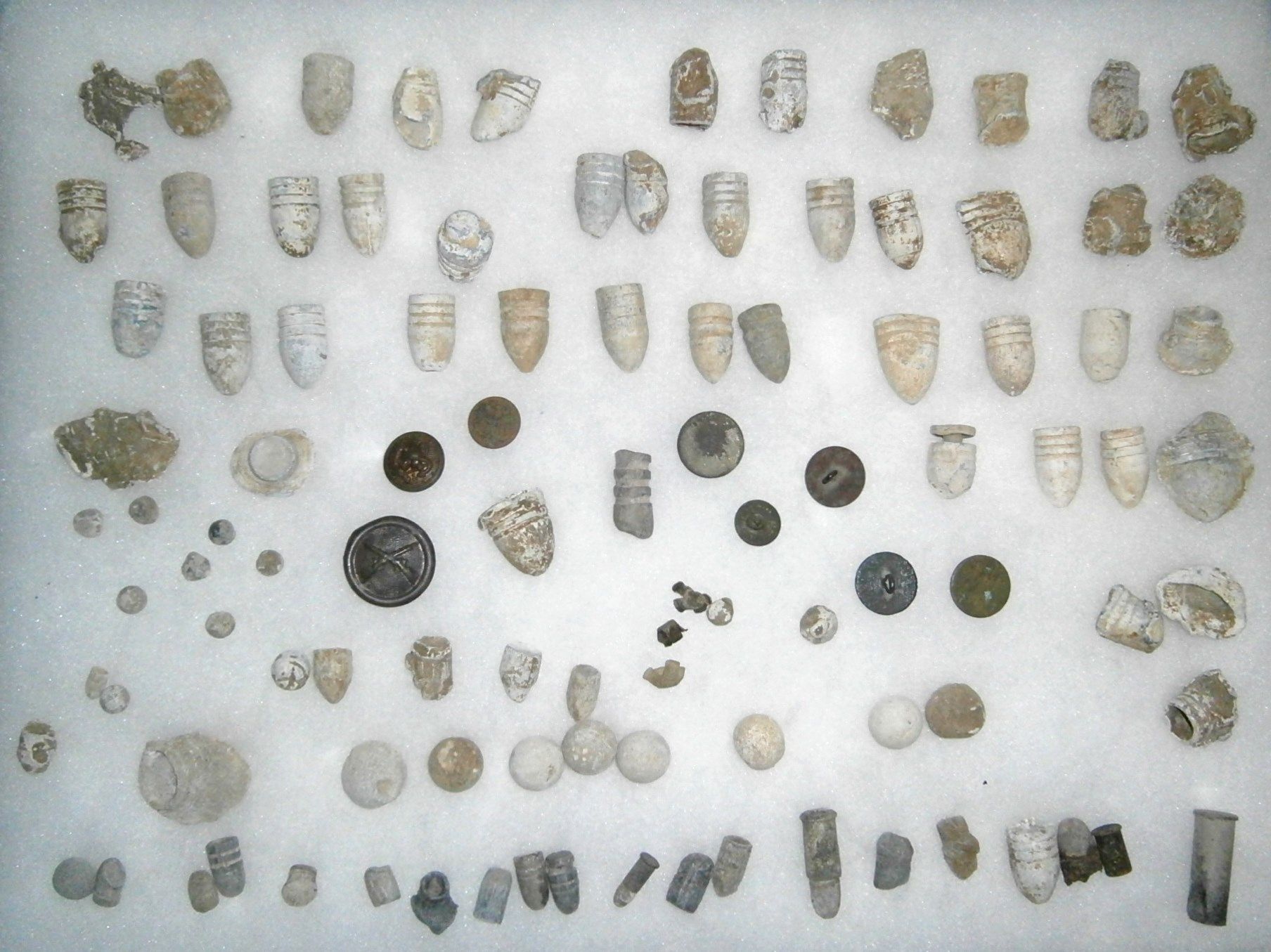 frame of Minie balls, various rifle and pistol lead balls, buttons, insignia, most from Alexandria VA found 1972-3 including one "nipple protector" mi