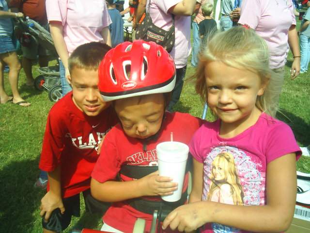 Hunter and his big brother Jacob and little sister Kirstin when he was presented with his own AMTRAC tryke